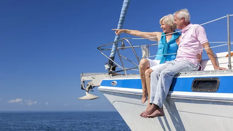 Frau sitzt mit Mann auf einem Segelboot