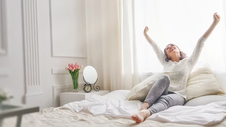 Frau reckt sich im Bett