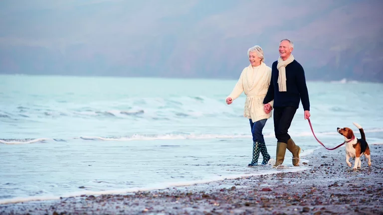 Mann und Frau mit Hund am Strand